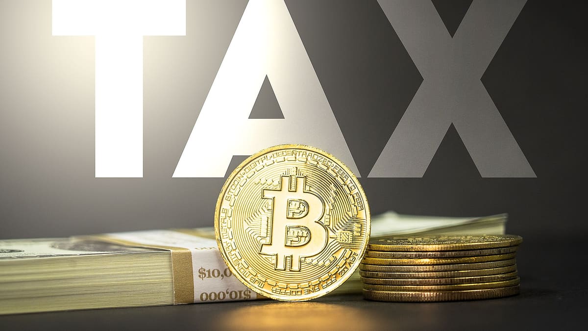 비트코인 메달과 현금, TAX 문구가 함께 놓인 코인 세금 개념 이미지