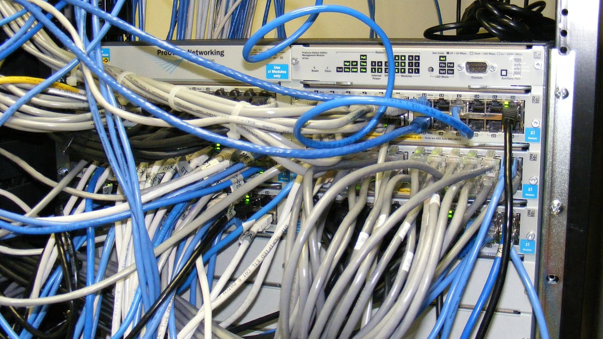 수많은 랜 케이블이 연결된 네트워크 스위치, API 키 보안과 IP 화이트리스트를 설명하는 이미지